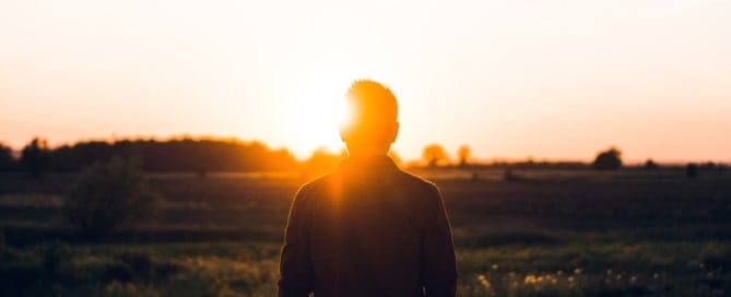 Man in open field at sunset