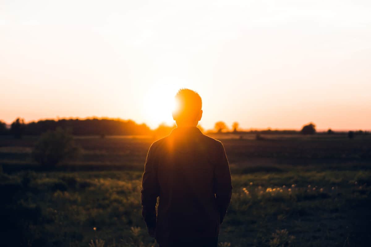 Man in open field at sunset