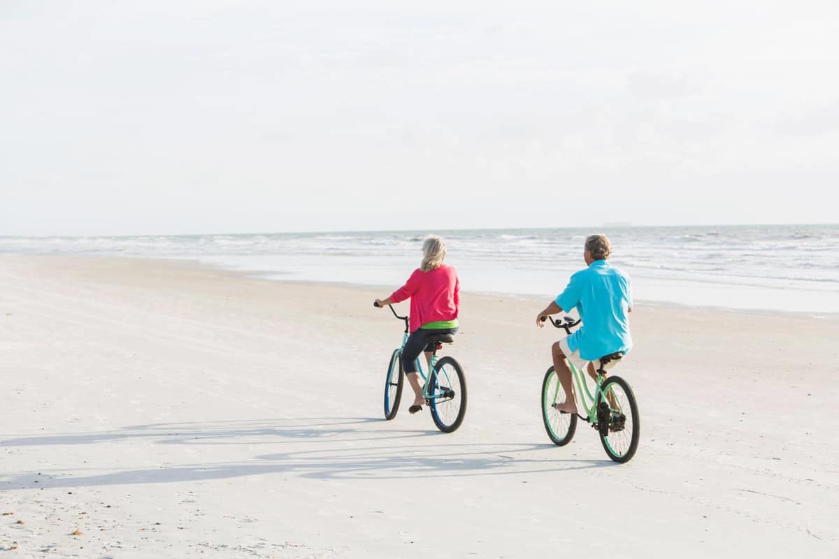 Couple riding bikes on the beach
