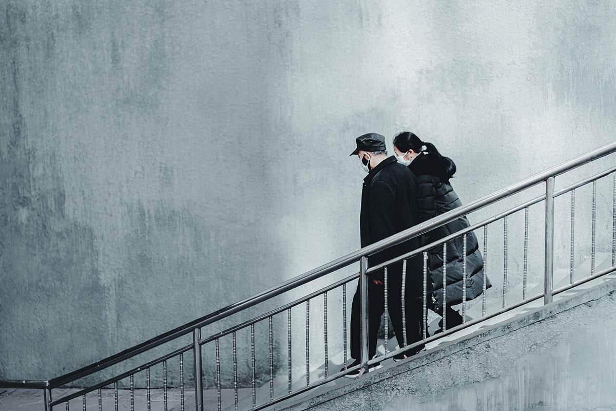 Cremation-During-COVID-19 Couple walking downstairs with masks on
