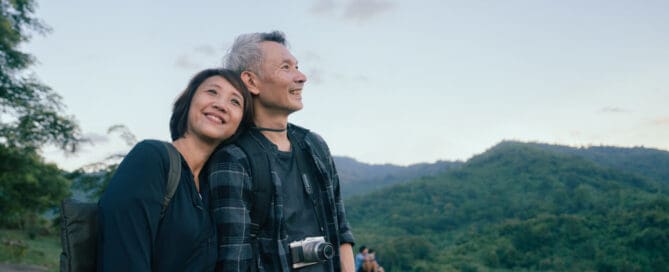 Smiling mature couple enjoying a serene hike, embodying the peace and freedom one might associate with choosing cremation over traditional burial methods.
