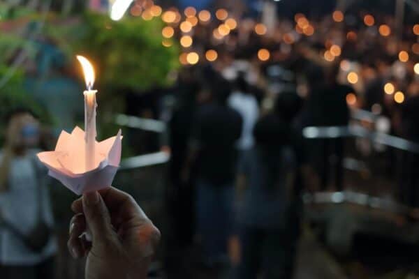 Participants hold candles during a memorial service