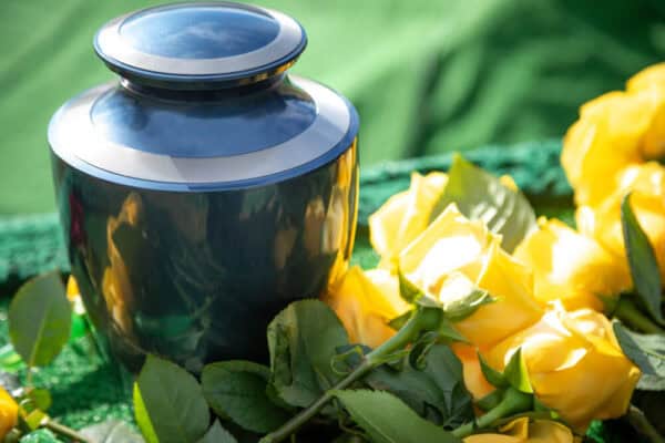 A burial urn surrounded by yellow roses