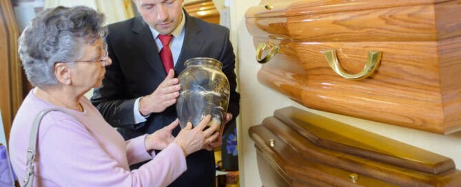 A cremation provider showing an older woman an urn