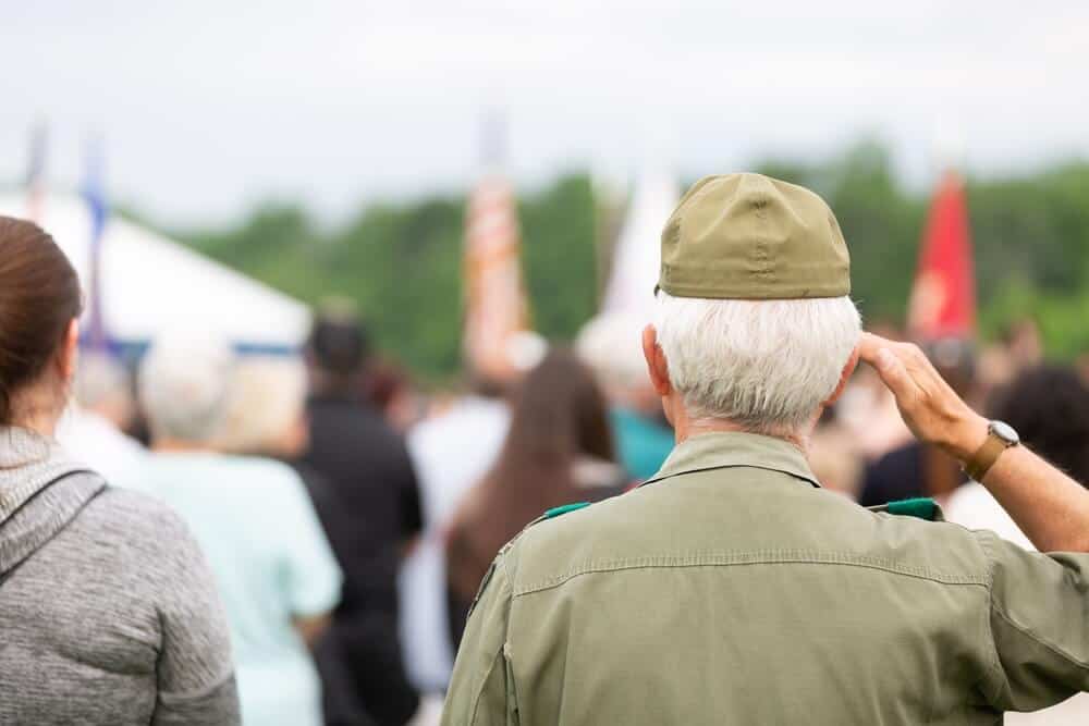 Veterans can save on funeral costs. Veteran saluting during service member’s funeral.