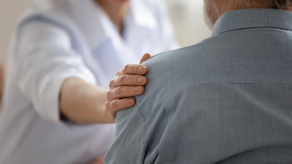 Older person comforted following the death of a loved one